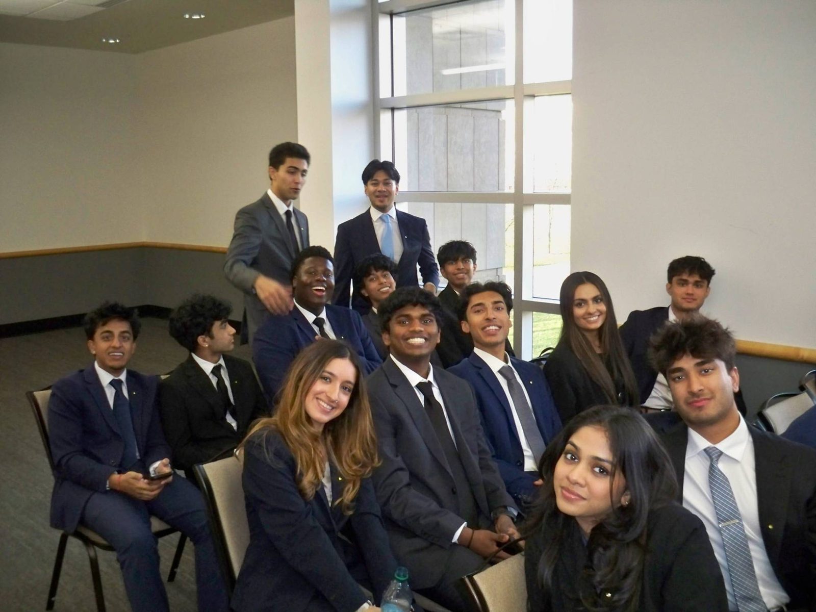 Omicron Tau members in business attire at a chapter meeting